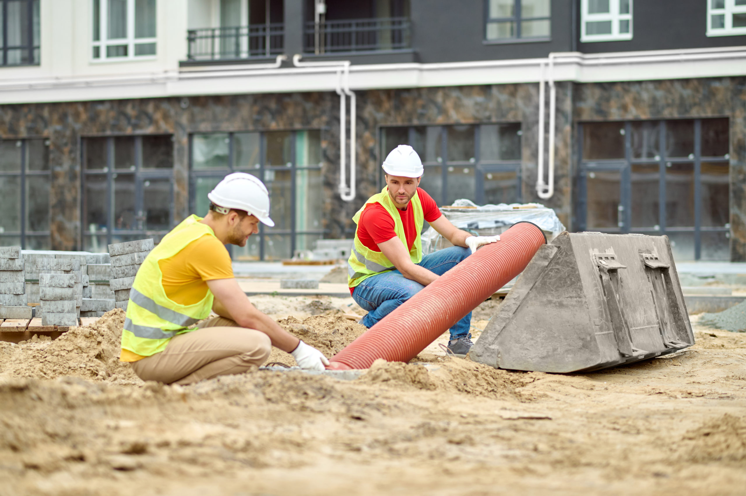 Pose de canalisation dans une tranchée de chantier